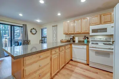 a kitchen with wooden cabinets and white appliances at Less Than 3 Mi to Lake Tahoe Incline Village Condo! in Incline Village