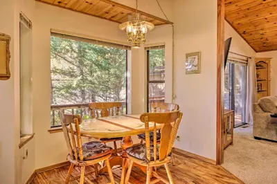 a dining room with a table and chairs and a window at Deck with Forest Views Quiet Twain Harte Cabin! in Twain Harte