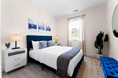 a bedroom with a large bed and a blue chair at Stylish 4BR Home Nr Golden Eagle Sports Complex in Sparks