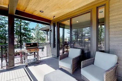 a screened in porch with two chairs and a grill at Gondola Vista Luxury Villas by Ski Heavenly & Beaches in South Lake Tahoe