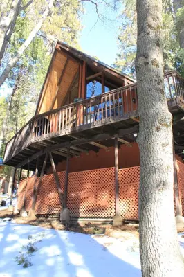 a tree house with a deck on the side of a tree at Cozy Sequoia Forest Cabin near Lake Isabella in Wofford Heights