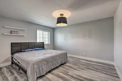 a bedroom with a bed and a large window at Modesto Home with Deck - 2 Mi to Vintage Faire Mall in Modesto