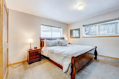 a bedroom with a bed and two windows at Comfort is Key Cabin in Incline Village