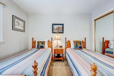 a bedroom with two beds and a table with a lamp at Comfort is Key Cabin in Incline Village