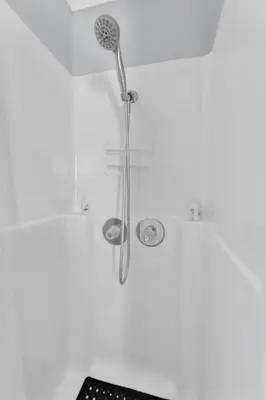 a shower in a white room with a shower at A Cottage - Walk to UC Davis & Shriners in Sacramento