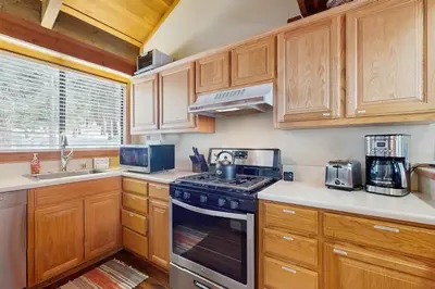 a kitchen with wooden cabinets and a stove top oven at Northstar's Cozy Condo in Truckee