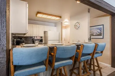 a kitchen with a table with blue chairs in a room at Mammoth Ski and Racquet 71 in Mammoth Lakes
