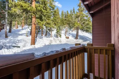 a balcony with a view of a snow covered forest at Mammoth Ski and Racquet 71 in Mammoth Lakes