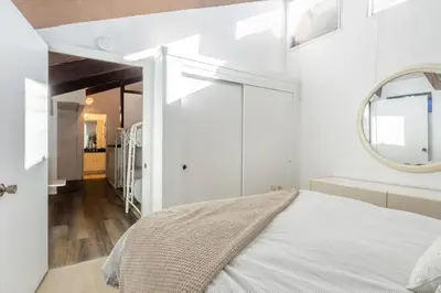 a white bedroom with a bed and a mirror at Mammoth Ski and Racquet 71 in Mammoth Lakes
