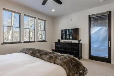 a bedroom with a large bed with a faux fur headboard at Creekhouse 1551 in Mammoth Lakes