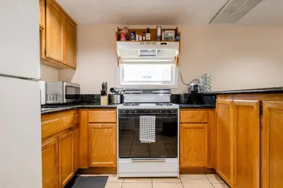 a kitchen with wooden cabinets and a stove top oven at *2bdr Victorian Home away from Home - *Central Loc in Sacramento