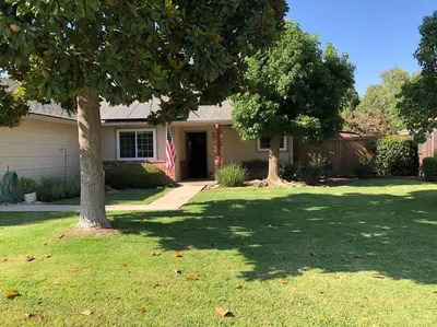 a house with a tree in a yard at Clovis, CA National Parks Room in Clovis