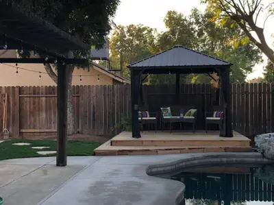 a gazebo with chairs and a table next to a pool at Clovis, CA National Parks Room in Clovis