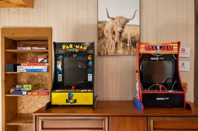 two arcade games sitting next to each other at Hygge Haus Sequoia - Large Private Cabin w Views in Ponderosa