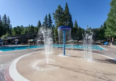 a water fountain in front of a swimming pool at Cozy Northstar Village Family Condo Walk to Lifts 2 Full BA Excellent Location in Truckee