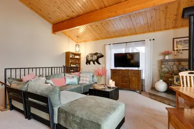 a living room with a couch and a tv at Hot Tub and Scenic Views Luxury Twain Harte Cabin! in Twain Harte
