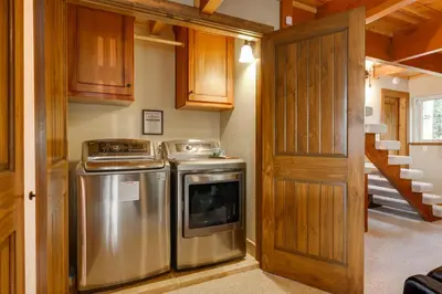 a kitchen with a stove and a washer and dryer at Hot Tub and Scenic Views Luxury Twain Harte Cabin! in Twain Harte