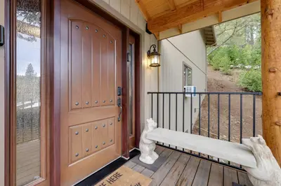 a porch with a bench next to a door at Hot Tub and Scenic Views Luxury Twain Harte Cabin! in Twain Harte