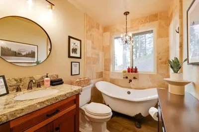 a bathroom with a tub and a toilet and a sink at Hot Tub and Scenic Views Luxury Twain Harte Cabin! in Twain Harte