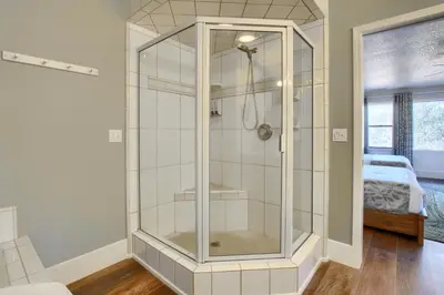 a glass shower in a room with a bed at NEW! Yosemite Mountain villa, stunning views -more in Oakhurst
