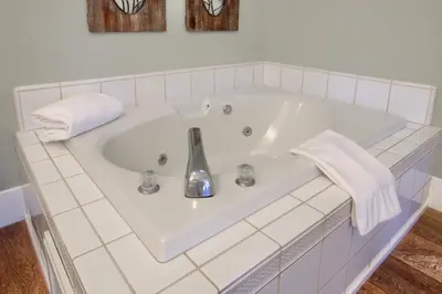 a white bath tub with a sink and towels at NEW! Yosemite Mountain villa, stunning views -more in Oakhurst