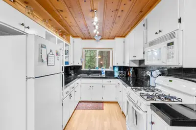 a kitchen with white cabinets and a wooden ceiling at Vacation Valhalla in Arnold