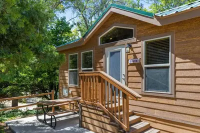 a wooden cabin with a porch and a bench outside at Quiet little pet friendly cabin in Kernville