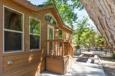 a wooden house with a porch and a picnic table at Adorable little cabin #21 in Kernville