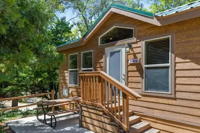 a wooden cabin with a porch and a door at Adorable little cabin #28 in Kernville