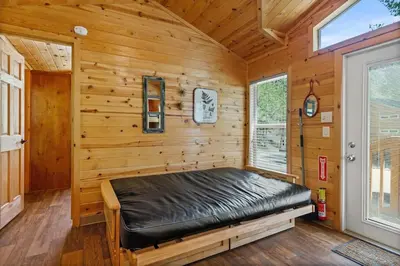 a room with a bed in a log cabin at Deluxe little cabin 2 min stroll to Kern River in Kernville