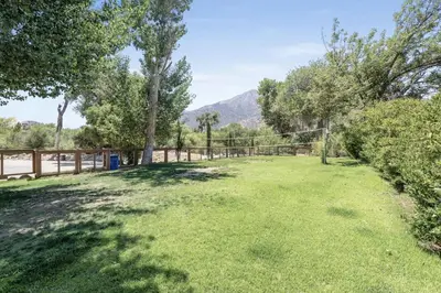 a large yard with trees and a fence at Deluxe little cabin 2 min stroll to Kern River in Kernville