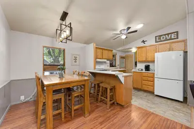 a kitchen with a wooden table and a white refrigerator at The Sequoia House in Kernville