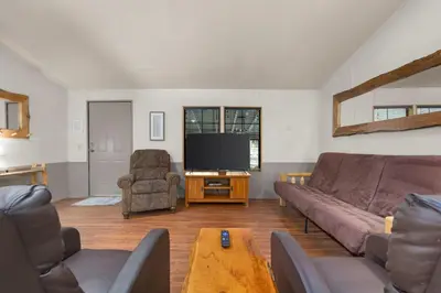 a living room with a couch and a flat screen tv at The Sequoia House in Kernville