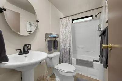 a bathroom with a sink and a toilet and a mirror at The Sequoia House in Kernville