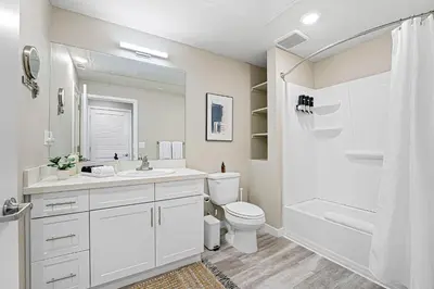 a white bathroom with a toilet and a sink and a shower at Designer Apt w Jacuzzi Walk To Casino & iMax in Sparks