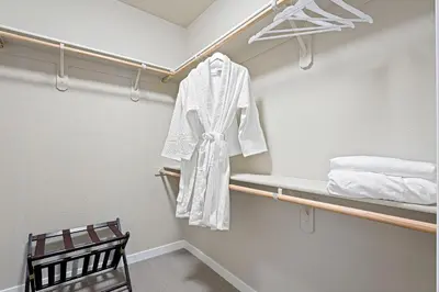a walk in closet with a white robe on a shelf at Designer Apt w Jacuzzi Walk To Casino & iMax in Sparks