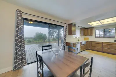 a kitchen with a wooden table and a large window at Pet-Friendly Hollister Getaway with Grill! in Hollister