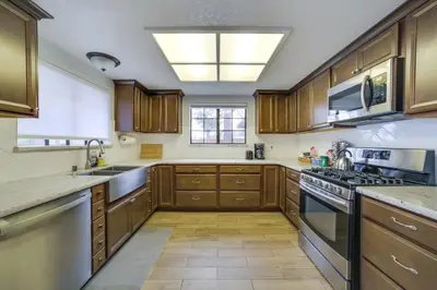 a large kitchen with wooden cabinets and a window at Pet-Friendly Hollister Getaway with Grill! in Hollister