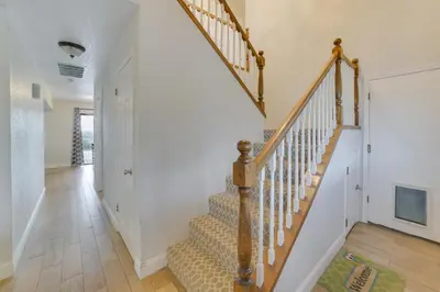 a staircase in a home with white walls and wooden floors at Pet-Friendly Hollister Getaway with Grill! in Hollister