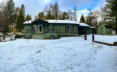 a green house in the snow in a yard at Fully-Stocked, Pet-friendly, Relaxing Home Near Yosemite and Bass Lake in North Fork