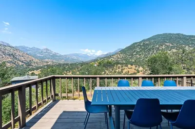 a table and chairs on a deck with mountains in the background at Mountain View, Hot Tub, Open Kitchen, 10m to Sequoia in Three Rivers