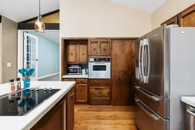 a kitchen with a stainless steel refrigerator and wooden cabinets at Mountain View, Hot Tub, Open Kitchen, 10m to Sequoia in Three Rivers