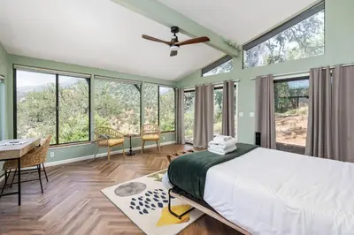 a bedroom with a bed and a desk and windows at Mountain View, Hot Tub, Open Kitchen, 10m to Sequoia in Three Rivers