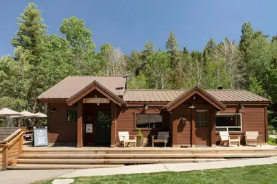 a log cabin with tables and chairs in front at Desolation Hotel Hope Valley in Markleeville