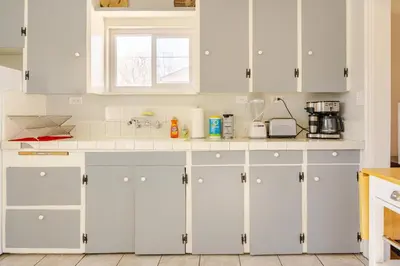 a white kitchen with white cabinets and a window at Midcentury Gem in Midtown Reno in Reno