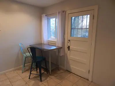 a small table and chairs in a room with a door at Midcentury Gem in Midtown Reno in Reno