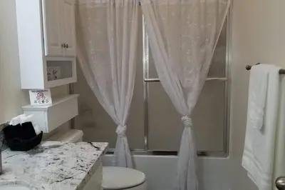 a bathroom with a shower and a toilet and a sink at Chateau Sunnyside in Fresno