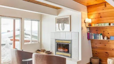 a living room with a fireplace and two chairs at Chickaree Chickadee Buyout by AvantStay 2 Sister Cabins in Tahoe City