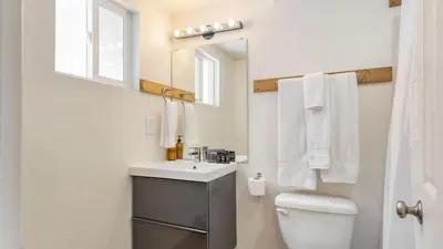 a bathroom with a sink and a toilet and a mirror at Chickaree Chickadee Buyout by AvantStay 2 Sister Cabins in Tahoe City