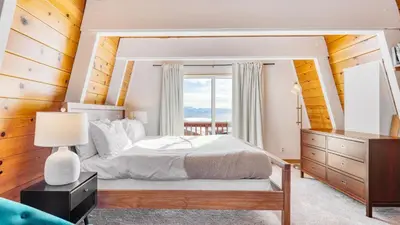 a bedroom with a large bed and a window at Chickadee by AvantStay Modern A-Frame Cabin in Tahoe City